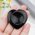 Polished black obsidian heart-shaped worry stone held in hand for stress relief - Obsidian
