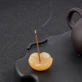 Handgesneden gele kristallen bloem wierookhouder met rook op een zwart dienblad - Topaz Stone Flower Incense Holder