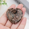 Polished pink and purple heart-shaped crystal stone with natural black veining - Rhodonite
