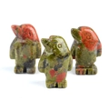 Three hand-carved unakite penguin figurines in natural green and pink stone patterns - Unakite