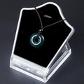 Dark green agate donut pendant necklace with brown braided cord on a display - India Agate