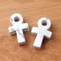 Weißer Türkis-Ankh-Kreuzanhänger mit grauem Marmormuster auf Holzgrund - Howlith