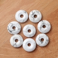 White howlite crystal donuts with natural grey marble textures on a wooden background - Howlite