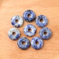 Eight natural blue Sodalite gemstone donut beads with white marbled patterns on wood - Blue Spot Stone