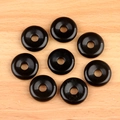 Eight polished black natural stone donut beads for DIY jewelry making on wood background - Obsidian