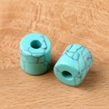 Cilindrische turquoise kralen met zwarte nerven op een natuurlijk houten oppervlak - Blauwe turquoise (Synthetisch)