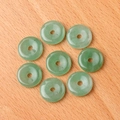Set of eight natural green stone donut pendants on a minimalist wooden background - Green Aventurine (1pc)