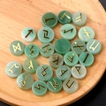 Natural green crystal Rune stone set with golden Norse engravings on a wooden tray - Green Aventurine