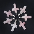 Set di sette ciondoli a croce in quarzo rosa naturale con ganci argentati su sfondo nero - Quarzo rosa