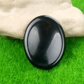 Pietra pollice in agata nera lucida a forma ovale su muschio decorativo verde - Ossidiana