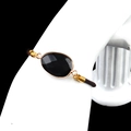 Adjustable dark brown braided bracelet with oval faceted black gemstone in gold bezel - Obsidian