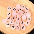 Runensteine-Set aus Rosenquarz-Kristallen mit goldener Gravur der Runen-Symbole - Rosenquarz