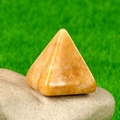 Gepolijste natuurlijke citrienkwarts piramide voor energie met interne texturen op steen - Gele Jade