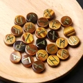 Set mit 25 Tigerauge Runensteinen mit goldenen Runen in einer Holzschale serviert - Tigerauge