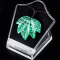 Malachite leaf pendant necklace with deep green stripes on a black velvet display base - Malachite