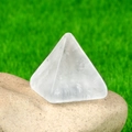 Clear natural quartz crystal pyramid ornament on raw stone with a garden background - White Crystal