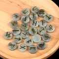 Natural labradorite rune stones set with golden engravings on a wooden tray - Labradorite