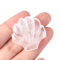 Sculpture de coquillage en quartz rose translucide tenue en main pour visualiser la taille - Cristal blanc