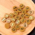 Orange natural crystal agate rune stones set with gold engraved lettering in a wooden bowl - Topaz