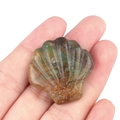 Main tenant un coquillage sculpté en agate et cristal naturel avec textures vertes - Agate d'Inde