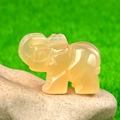 Mini handgeschnitzte Elefantenfigur aus gelbem Achat auf einem Flussstein-Sockel - Natürlicher Achat