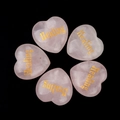 Set of five rose quartz heart stones with golden Healing inscription on black background - Healing
