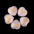 Rose quartz heart stones with gold Health engraving on a dark textured background - Health