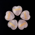 Pink heart rose quartz stones with gold gratitude engraving on black background - Gratitude