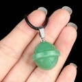 Green aventurine planet pendant with silver ring and black cord on hand - Planet Shape (1926) / Green Aventurine