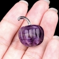 Mini natural amethyst pumpkin charm with silver metal stem held in palm of hand - Amethyst