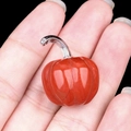 Mini red agate pumpkin ornament with silver stem held in hand for size display - Red Jasper