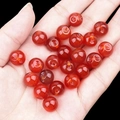 Hand holding polished red agate round beads with side holes for DIY jewelry making - Red Agate (2040)