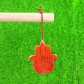 Natural red jasper Hamsa hand pendant with engraved eye on green background - Red Jasper