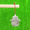 Hamsa Hand pendant in natural gray stone with Evil Eye carving on green moss background - Labradorite