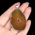 Natural amber agate slice pendant with silver electroplated edge held in hand - Yellow Agate (Silver Edge)