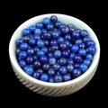 Polished natural Lapis Lazuli round beads in a beige ceramic bowl on black background - Lapis Lazuli (Single Bead) 4mm No Hole