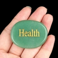 Pierre d'énergie aventurine verte avec gravure Health dorée tenue en main - Santé (Aventurine)