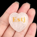 Pink heart-shaped crystal stone with gold Estj MBTI lettering displayed in hand - Executive/Estj