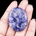 Polished blue sodalite worry stone with natural white veins held in hand for scale - Blue Sodalite