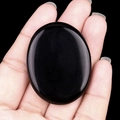 Polished black obsidian worry stone with a smooth oval shape and glossy finish - Obsidian