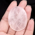Handheld oval rose quartz worry stone with natural pink crystalline texture and polished finish - White Crystal