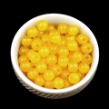 Spherical yellow agate crystal beads in a white ceramic bowl against a black background - 6mm-2mm Yellow Agate