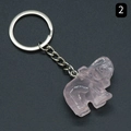 Pink rose quartz elephant keychain with silver metal ring on a dark textured background - Rose Quartz