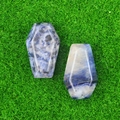 Mini coffin-shaped natural sodalite stones with blue and white patterns on green grass - Blue Sodalite