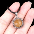 Hexagon silver framed yellow crystal pendant necklace held in hand on black background - Topaz (Silver)
