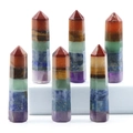 Polished seven chakra energy stones in hexagonal column shape on white display blocks - Default