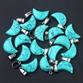Blue synthetic turquoise moon-shaped pendant charms with silver metal clasps on black sand - Blue Turquoise