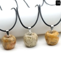 Three apple-shaped natural stone pendants with black cords on a white stand - 20mm Crazy Agate