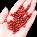 Polished translucent red agate round beads for DIY jewelry making held in hand - 6mm Diameter 2mm Hole