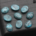 Oval turquoise stones with green and black marble texture on a black jewelry board - Gray Picture Stone (Dyed)